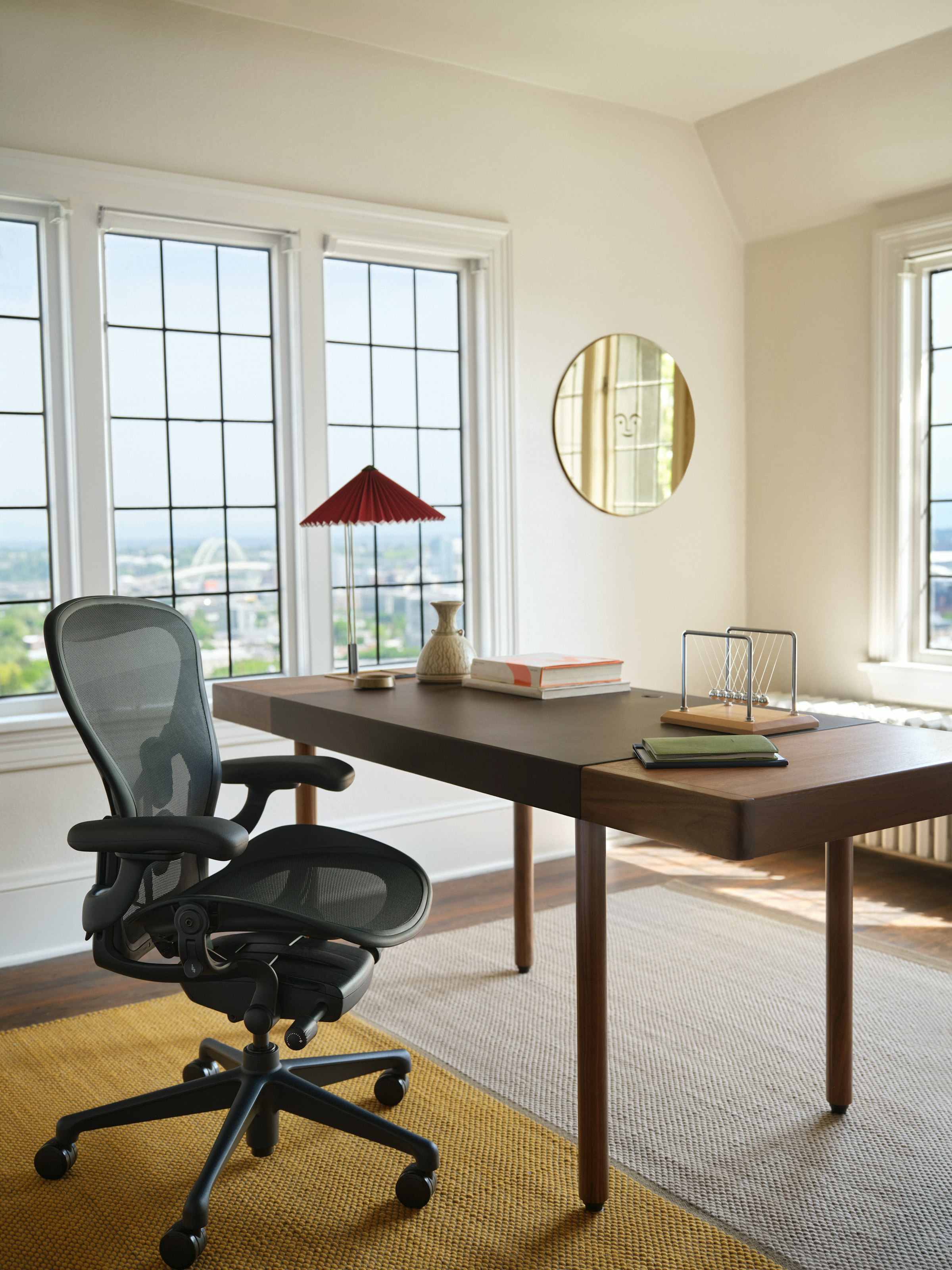 Herman Miller Aeron Nightfall at a walnut desk by tall windows